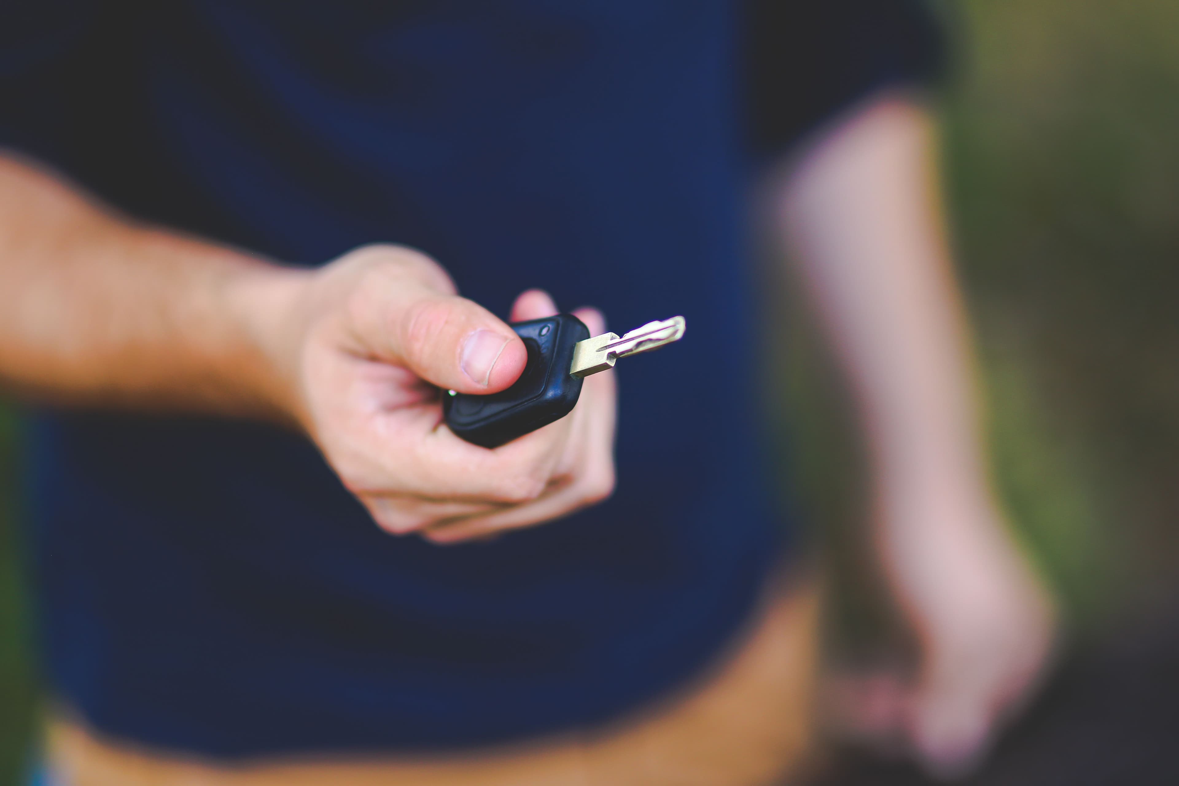 A host handing over car keys to a renter